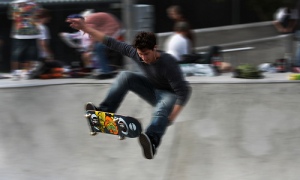 Blurred action shot of a man doing a jump with his skate board